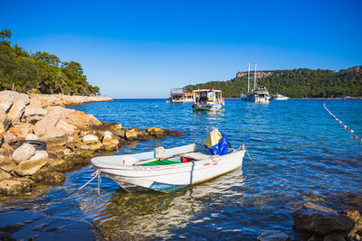 Boats in sea against clear sky