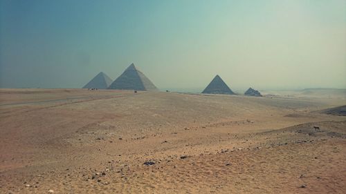 Scenic view of pyramids in desert against sky
