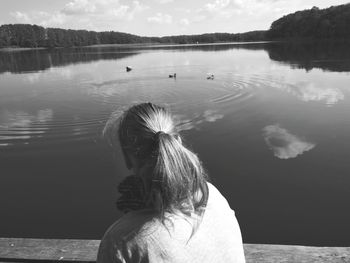 Woman looking at view against lake during sunny day