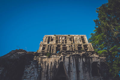 Low angle view of old building against clear blue sky