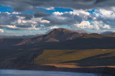 Scenic view of sea and mountains against sky