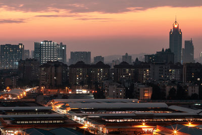 High angle view of illuminated cityscape against sky during sunset