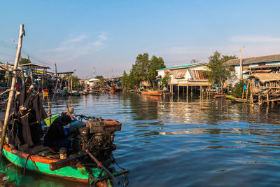 Boats moored in water against sky