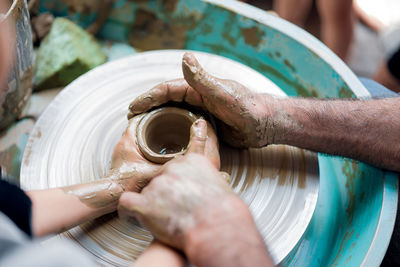 High angle view of man teaching child pottery