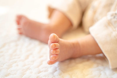 Low section of baby feet on bed