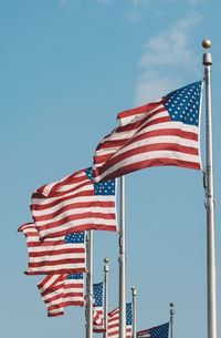 Low angle view of flag against clear blue sky