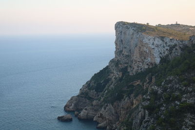 Rock formations by sea against sky