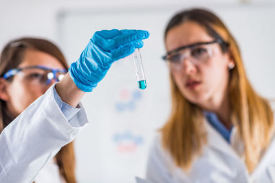 Female scientists examining chemical in laboratory