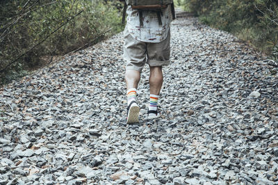 Low section of boy standing on pebbles