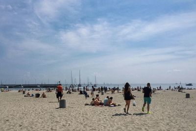 People on beach against blue sky