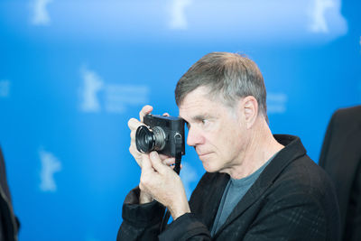 Man photographing against blue sky