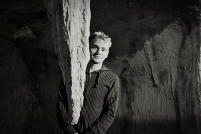 Young man standing against wall