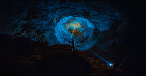 Man inside a cave with flashlight 