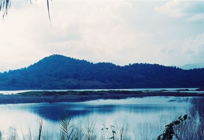 Scenic view of lake by mountains against sky