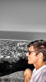 Man wearing sunglasses and sea against clear sky