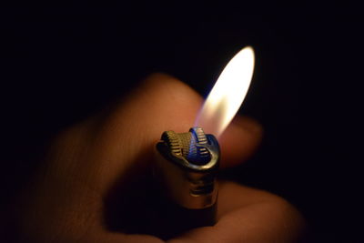 Close-up of illuminated candle in darkroom