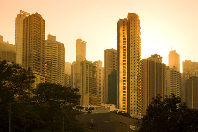 Sunset behind skyline of apartment buildings in the neighborhood of chung wan, hong kong, china.