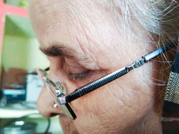 Close-up of senior woman wearing eyeglasses at home