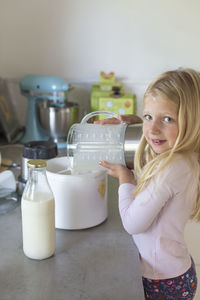 Smiling girl preparing food at home