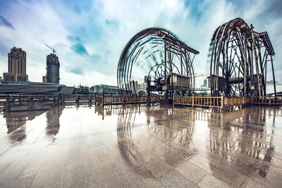 Spinning water wheels city against sky