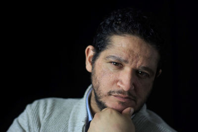 Close-up portrait of man against black background