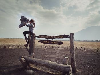 Wooden logs on field against sky