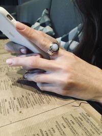 Cropped hands of woman using smart phone