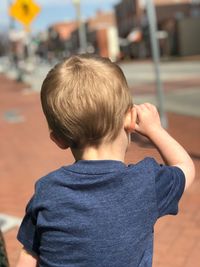 Rear view of boy in city