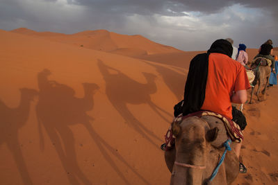 Tourists riding camels in desert