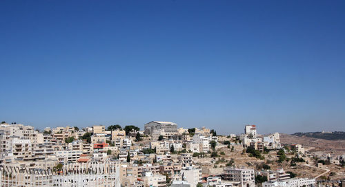 High angle view of cityscape against clear blue sky