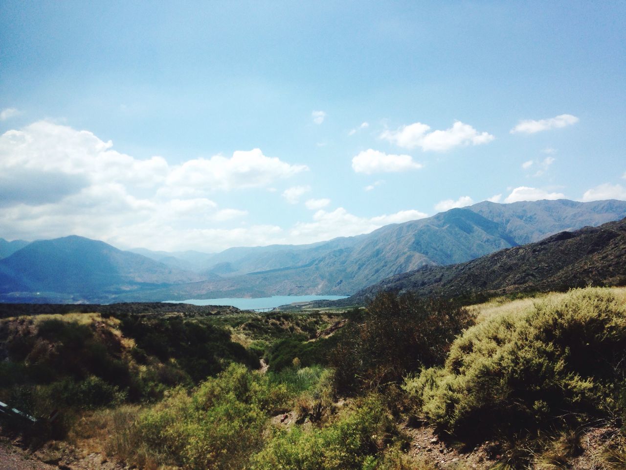 mountain, mountain range, tranquil scene, tranquility, sky, scenics, landscape, beauty in nature, nature, grass, cloud - sky, cloud, non-urban scene, idyllic, blue, countryside, remote, day, plant, outdoors