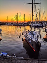 Sailboats moored at harbor