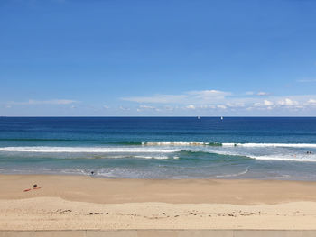 Scenic view of beach against blue sky