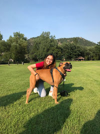 Young woman with dog standing on field