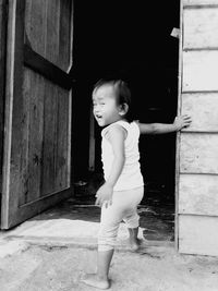 Cute girl standing against door