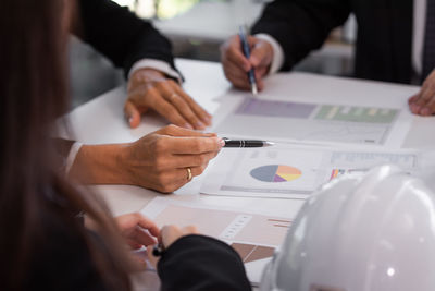 Midsection of business people working on table