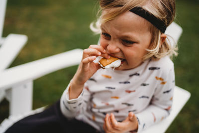 Young male toddler eating s'mores