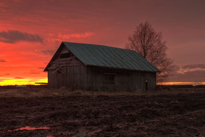 House on field against sky during sunset