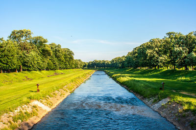 Scenic view of canal amidst trees against sky