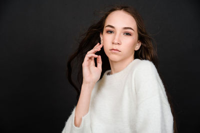 Portrait of a beautiful young woman over black background