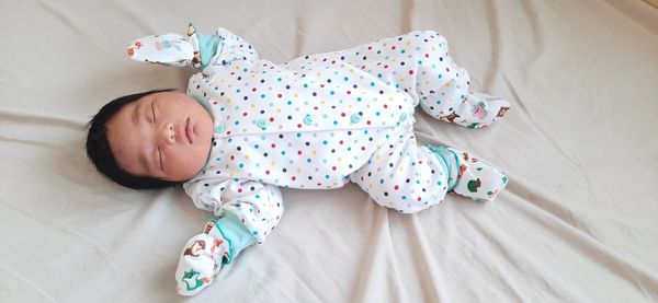 High angle view of baby sleeping on bed