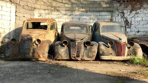 Old abandoned vintage cars against wall