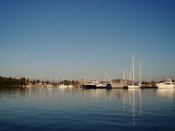 Sailboats moored in sea against clear sky