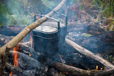 High angle view of food in containers cooking over campfire