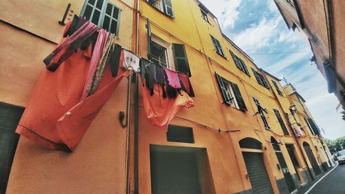 Low angle view of clothes drying on balcony against sky