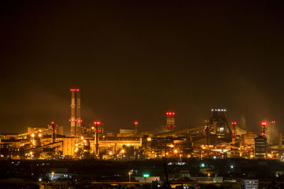 Illuminated city against sky at night