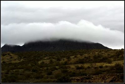 Scenic view of mountains against cloudy sky