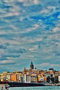 View of cityscape against cloudy sky