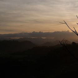Scenic view of silhouette mountains against orange sky