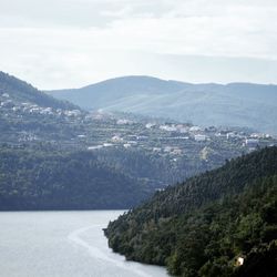 Scenic view of sea and mountains against sky